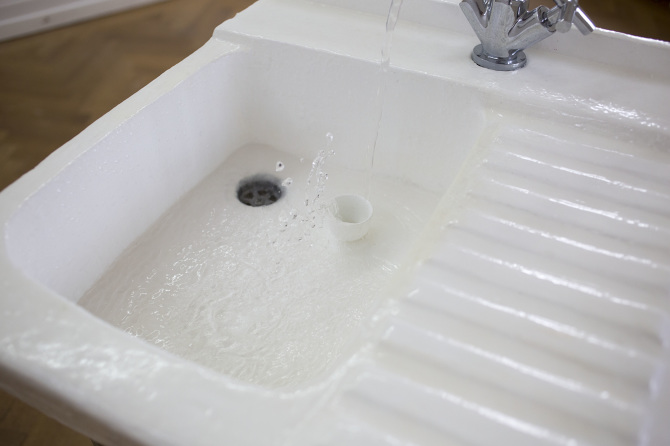 A tap running flow of water that splashes endlessly, and then down into the drain, 2017