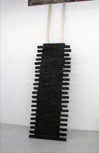 Gegen die Wand, 115 x 410 x 80 cm, Rauminstallation, angekohlte Holzstück, Holzlattern, 2012