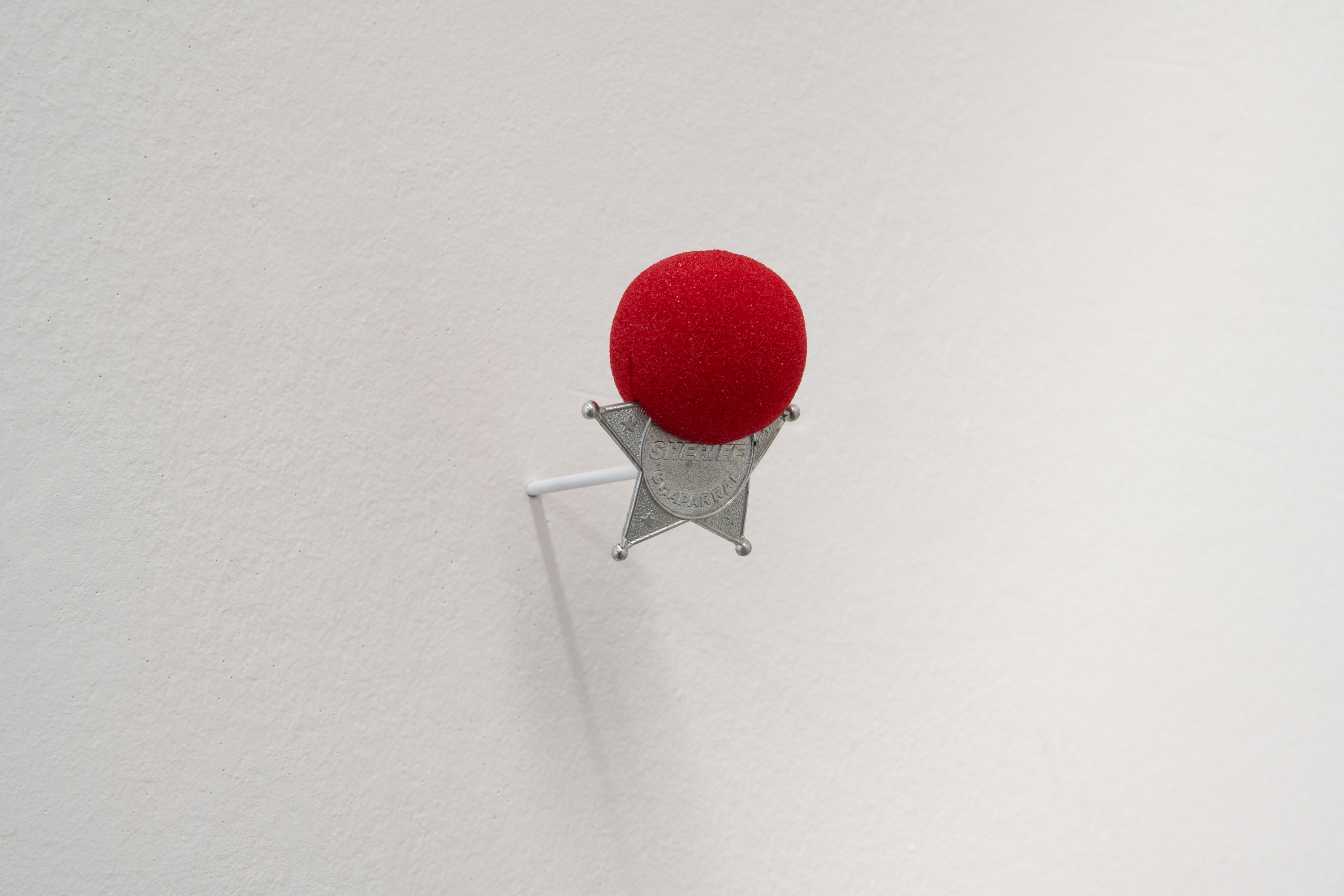 Daniel Drabek, *Untold jokes*, 2025. Clown nose prop, sheriff’s star prop, 9 × 7 × 5 cm. Photo: Finn Curry.
